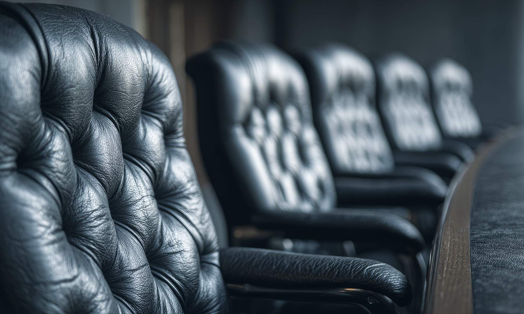 Empty leather chairs along a government hearing dais, the seat at the table in government affairs